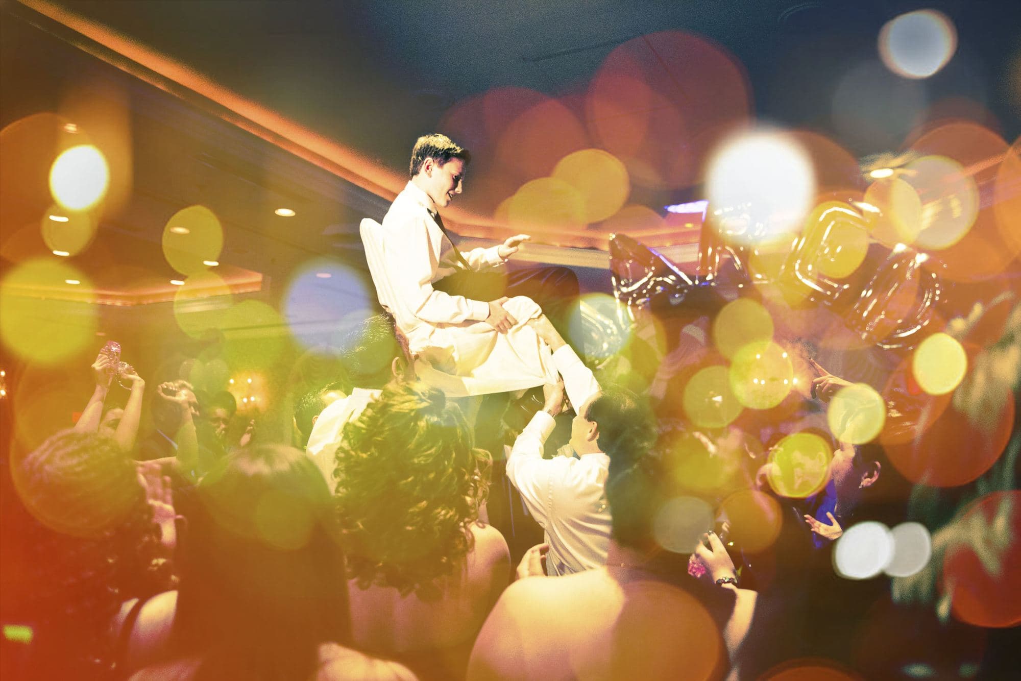 Guest lifted on a chair during a wedding celebration